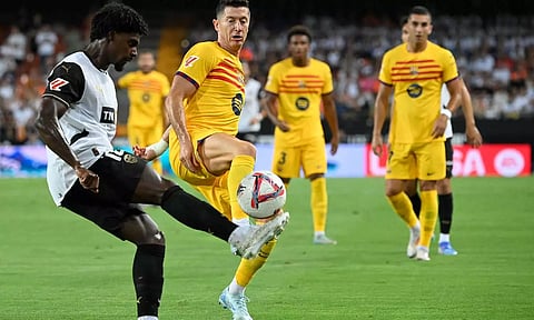 Valencia defender Thierry Correia and Barcelona forward Robert Lewandowski vie for the ball 